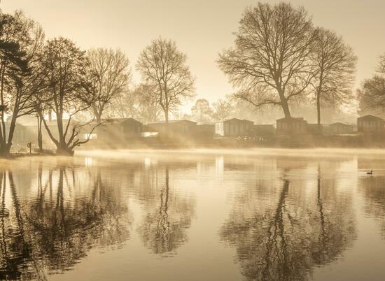 Sunrise over the lake and the lakeside holiday homes at Pearl Lake Herefordshire